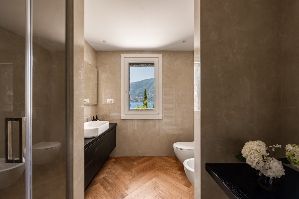Bathroom with herringbone parquet floor, dark vanity and lake view window