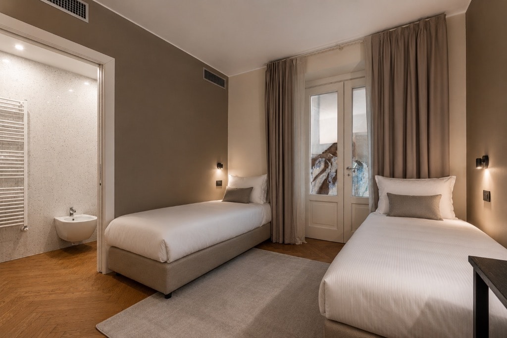 Twin bedroom with upholstered headboards and soft linen bedding