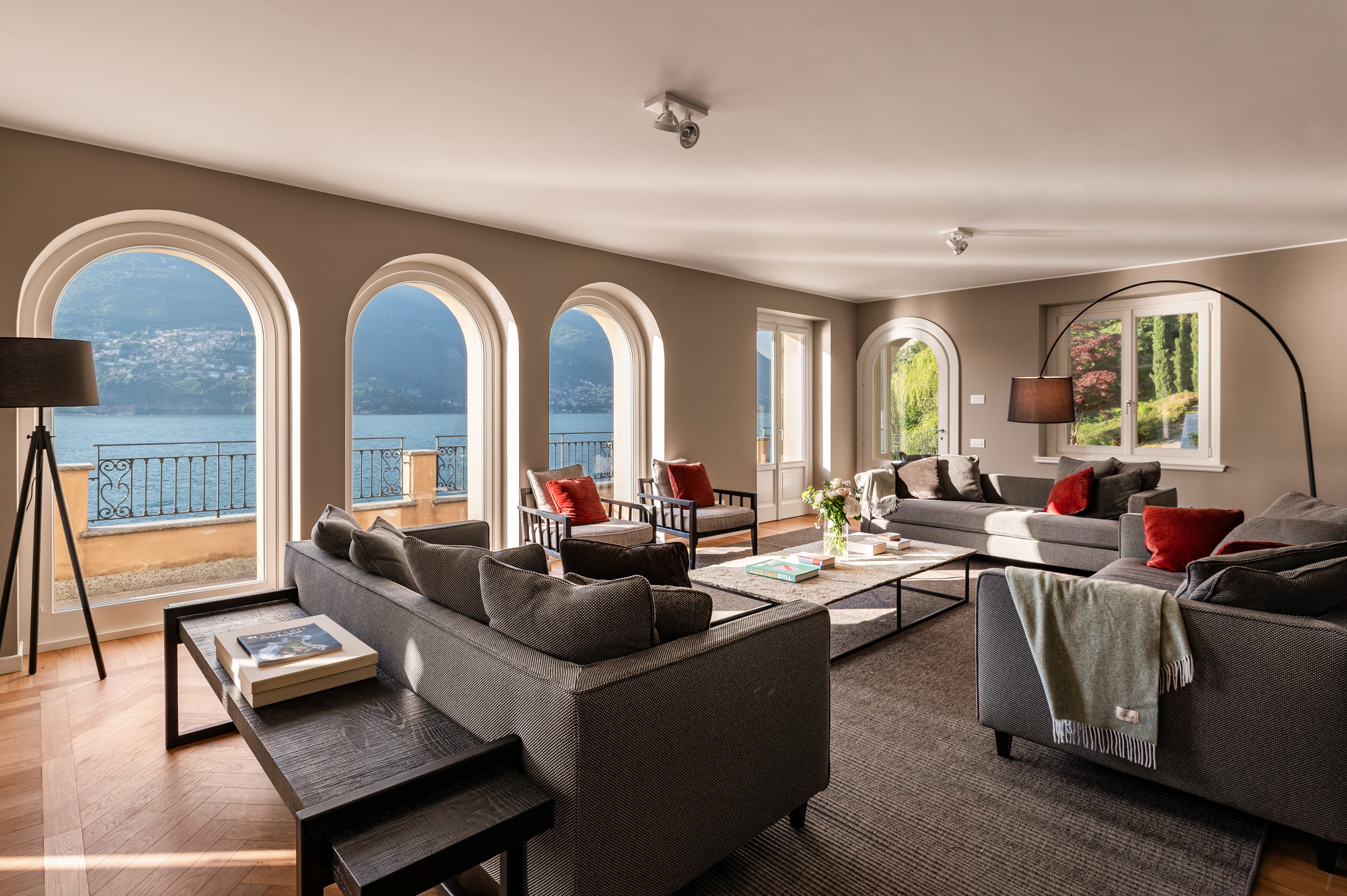 Grand living room with triple arched lake-view windows, herringbone parquet and generous seating