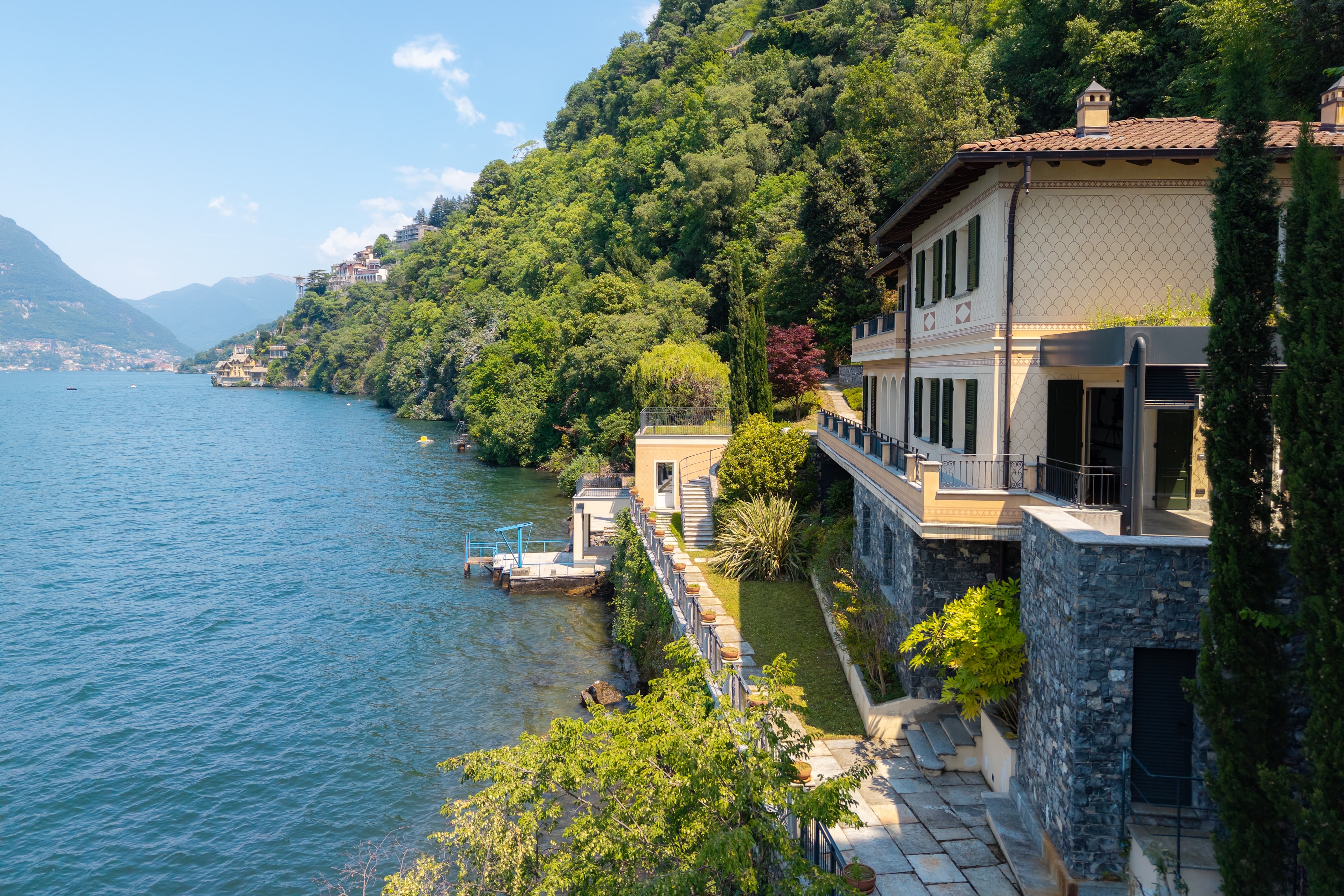 Villa Del Sole exterior from the lake — terraced gardens, private dock and cypress-lined facade