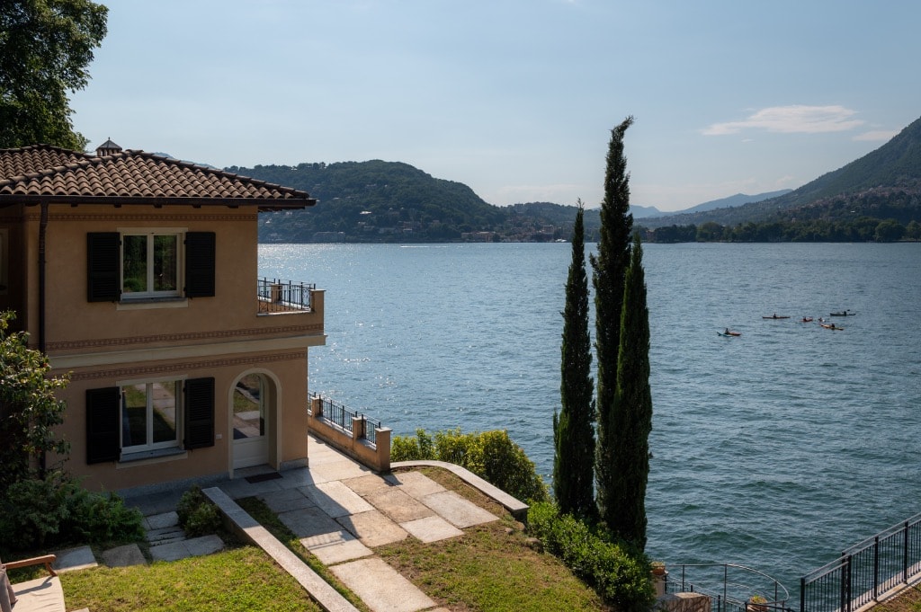Villa Del Sole facade above Lake Como, framed by cypress trees